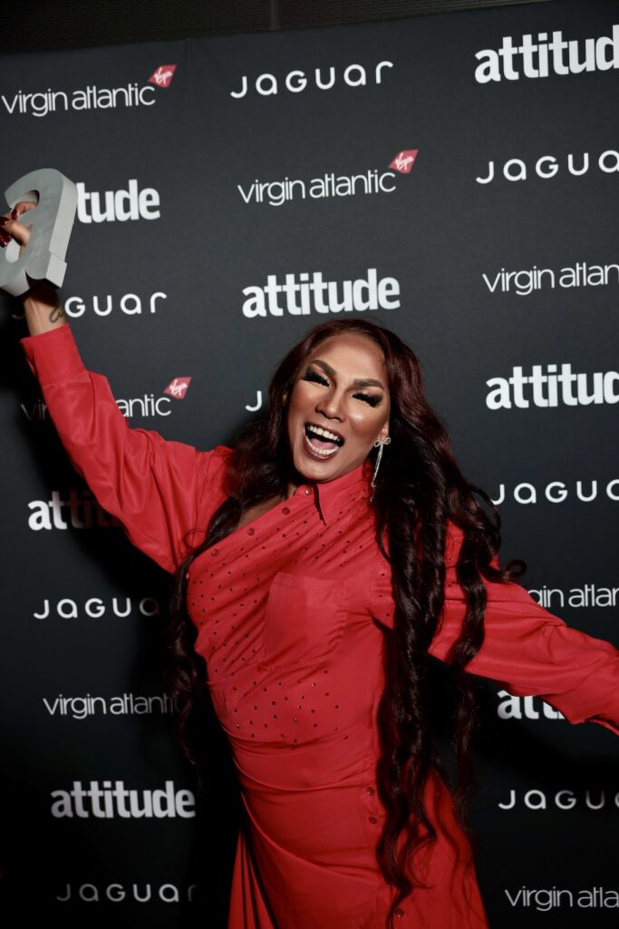 Tiara in a red Dres holding award in the air