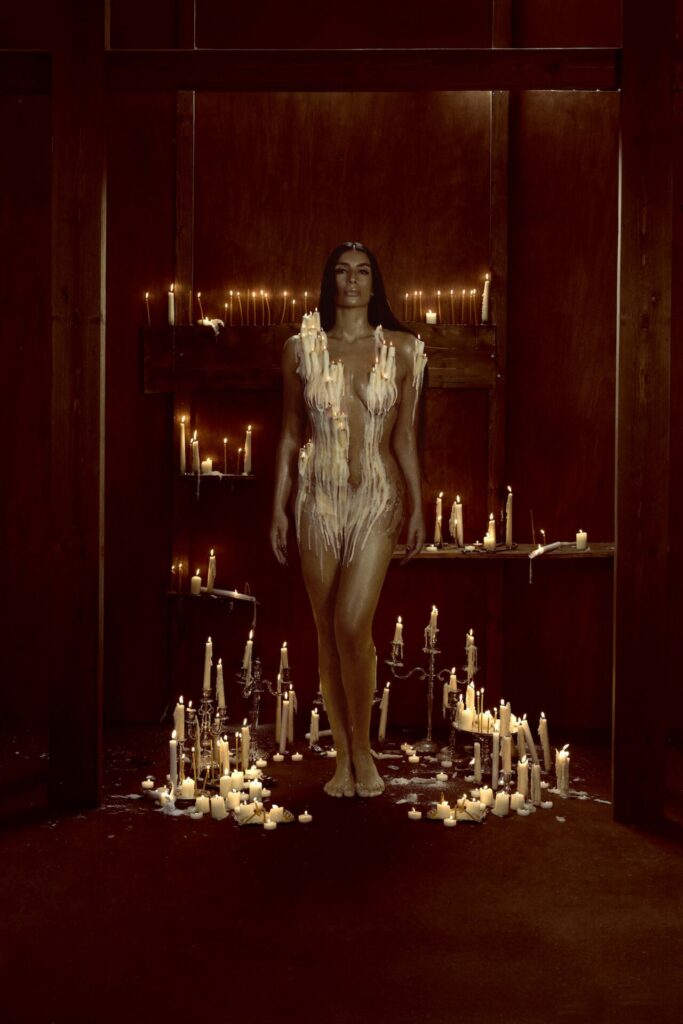 Sevdaliza in a wax candle dress in a red room full of candle sticks 