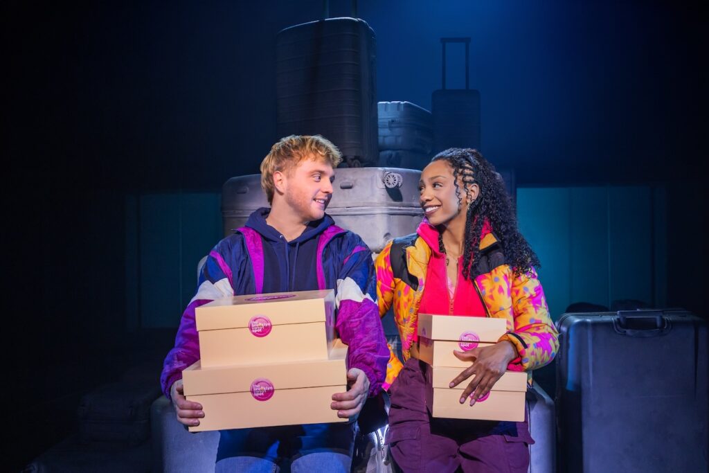 Christiani Pitts and Sam Tutty in Two Strangers (Carry a Cake Across New York holding boxes