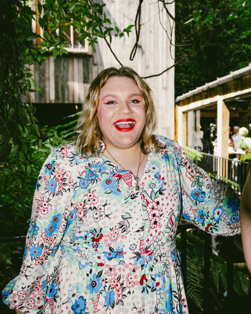 Ben Pechey smiling wearing red lipstick 