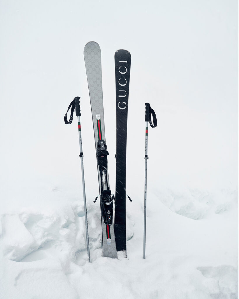 Lifestyle shot of the Gucci Altitude collection skis and poles in collaboration with HEAD