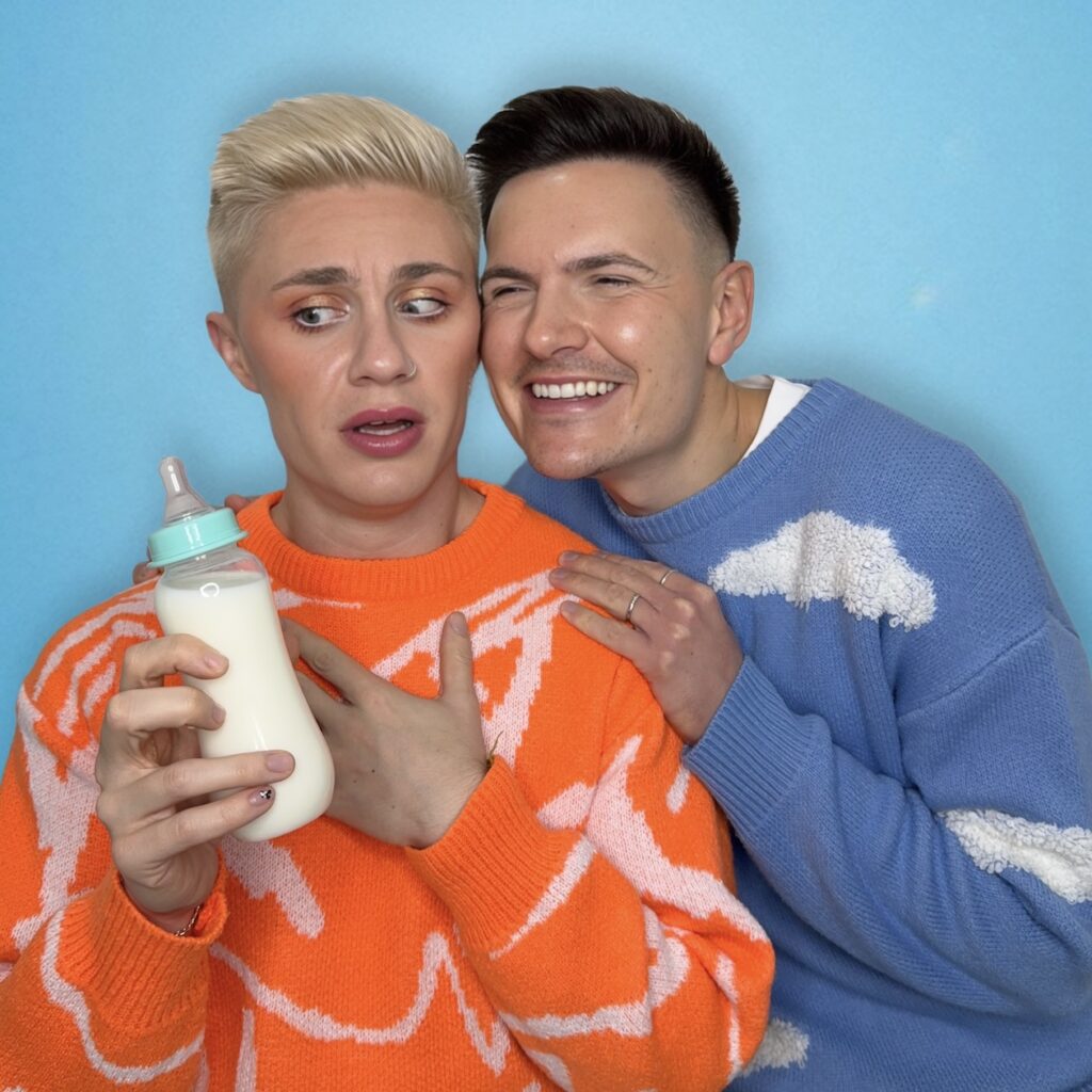 Matthew & Ryan Mackinnon wearing orange and blue holding a baby bottle