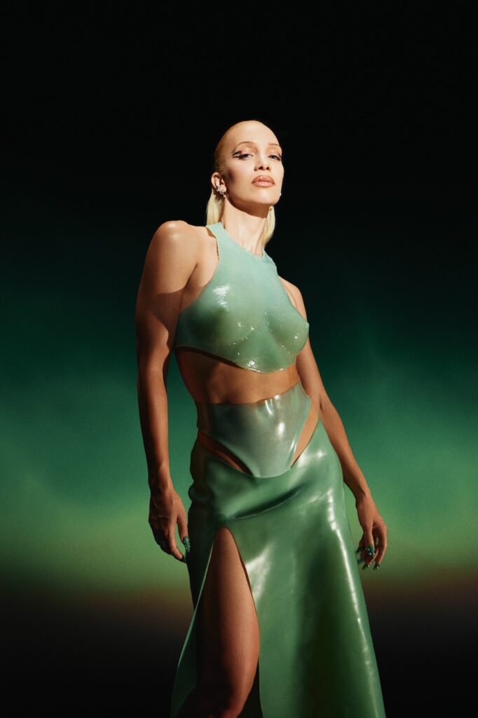 agnes in green dress with a green and black background