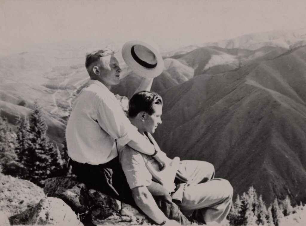 a couple lying on rocks and holding each other and sitting on the top of a mountain