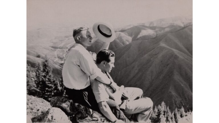 a couple lying on rocks and holding each other and sitting on the top of a mountain