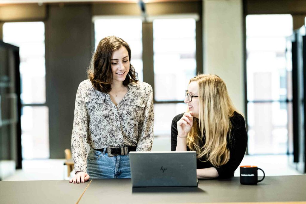 Two colleagues chatting over a laptop