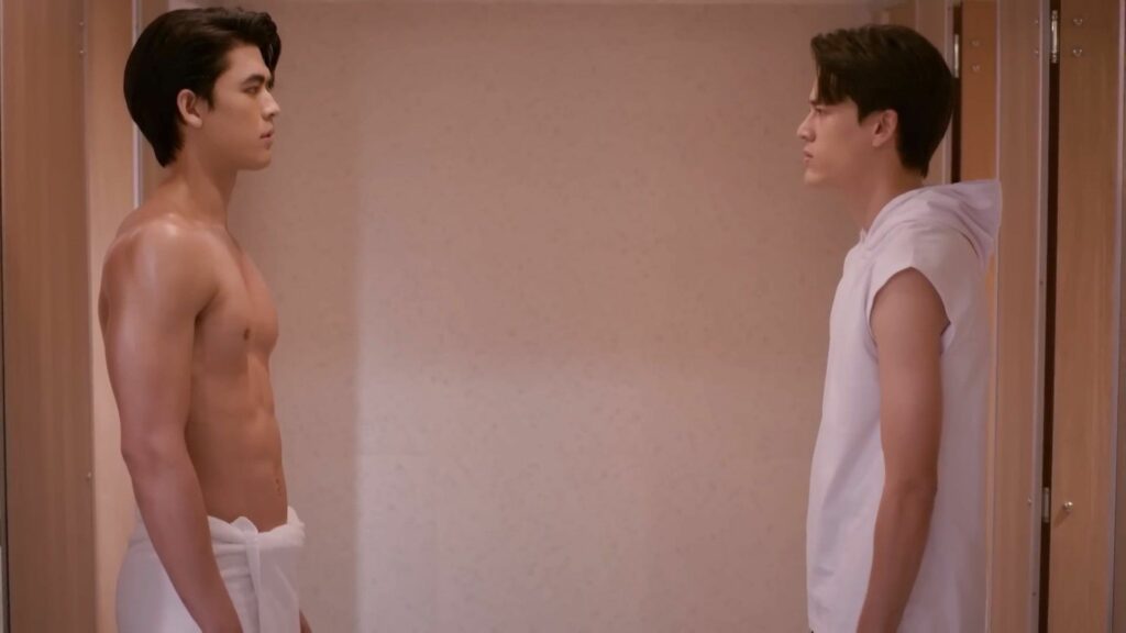 A shirtless man in a towel stands and glances at another man in Thai BL series My Golden Blood