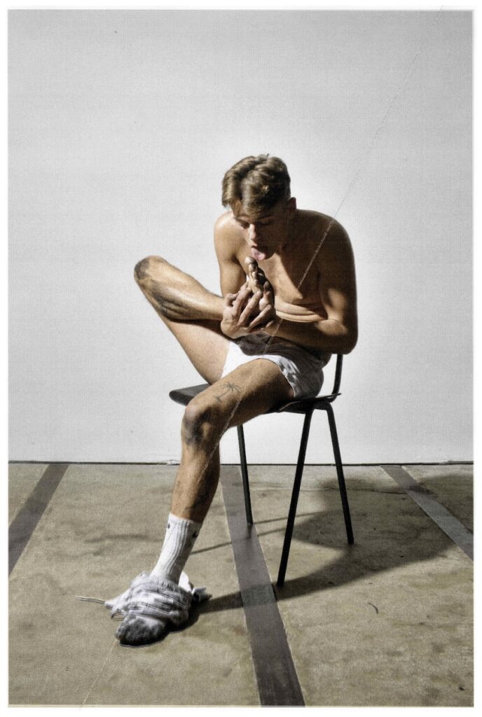 MANDATUM &copy; Yves de Brabander - a man sat on a chair in white underwear and licking his foot