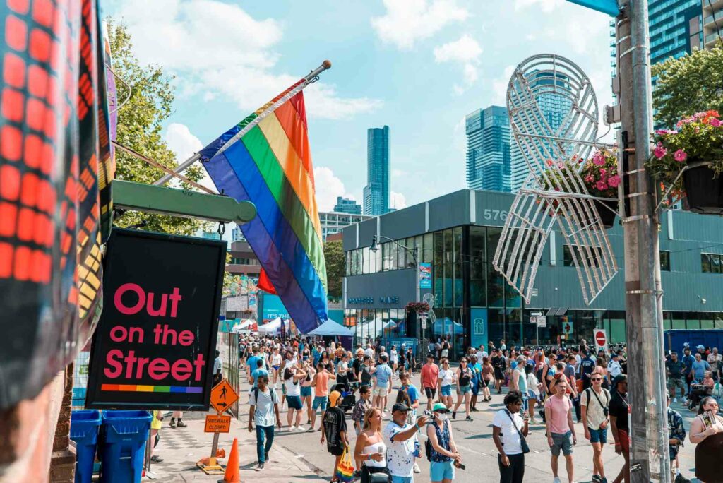 A busy Toronto street with Pride flags haging from a building