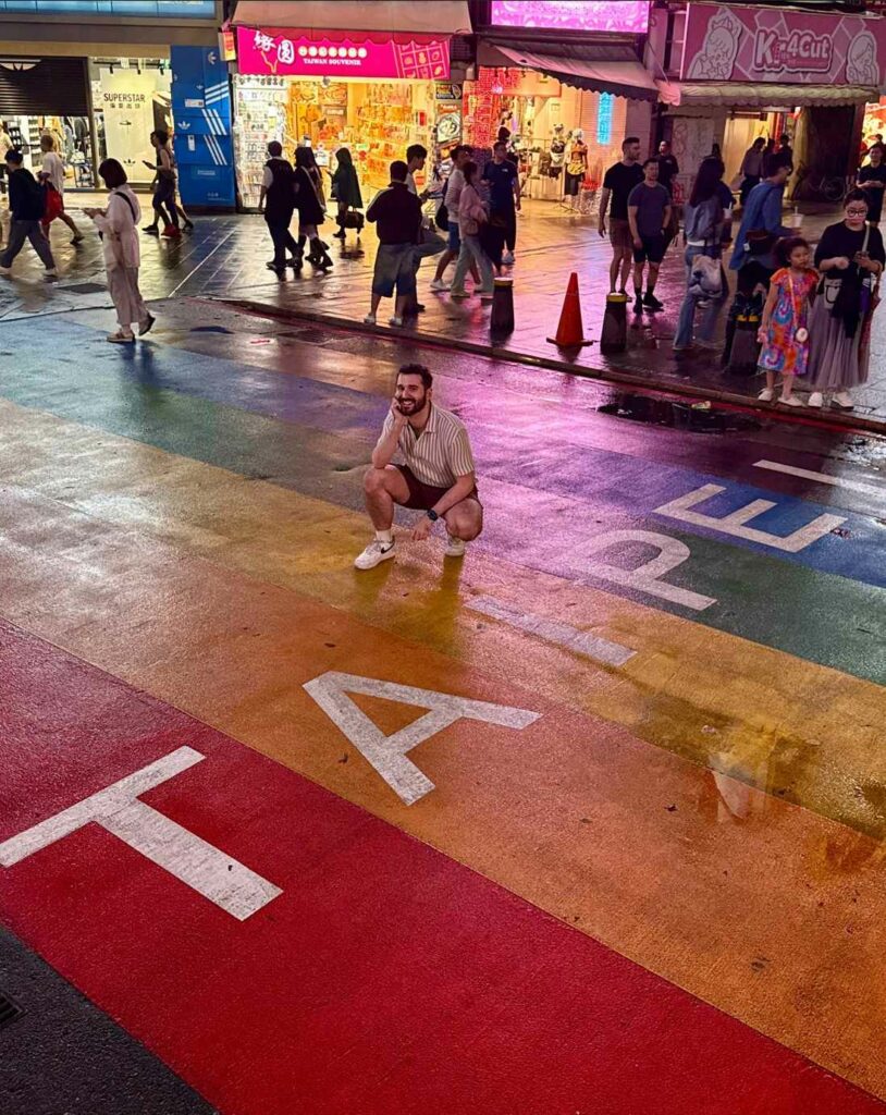 A person crouching on the Rainbow Crosswalk in Taipei