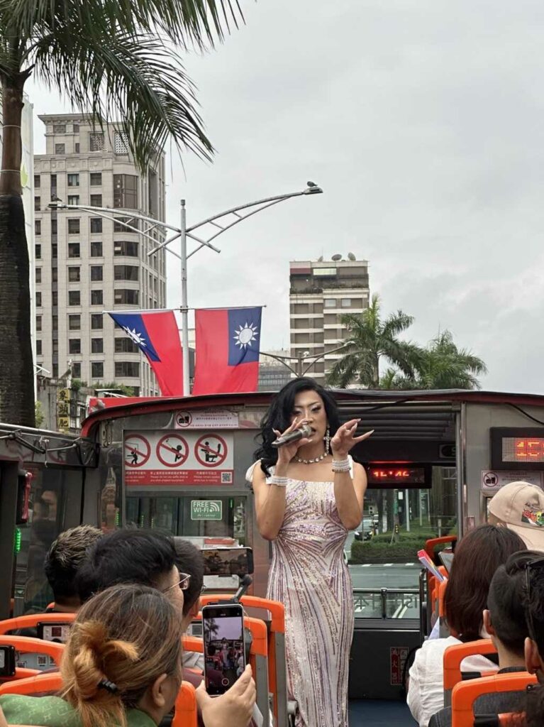 Drag queen Honey Boo Boo talks on a mic on the Rainbow Bus at Taiwan Pride 2025
