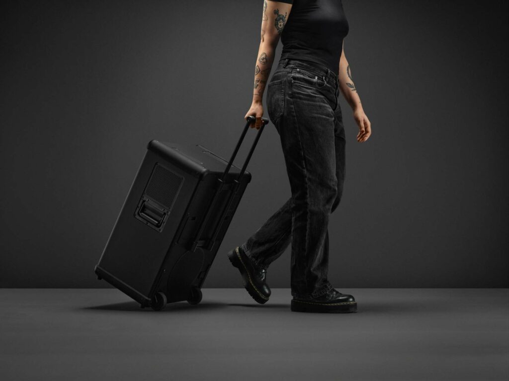 A shot of the Marshall Bromley 750 speaker showing a person carrying it by its handle