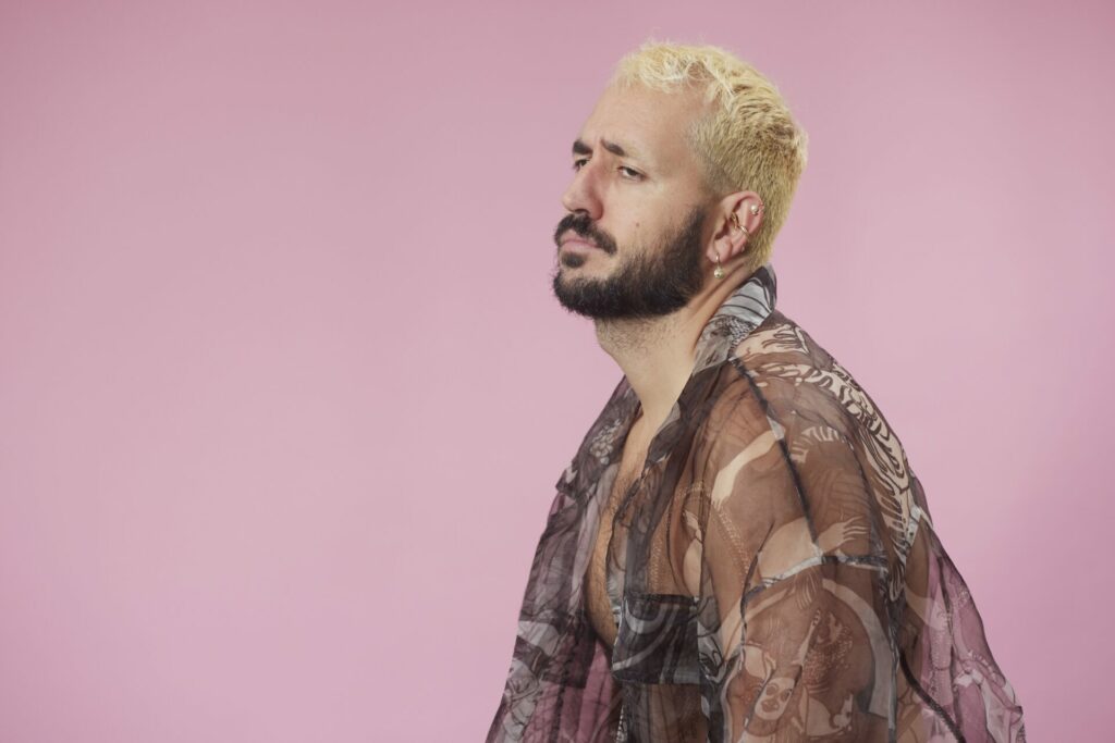 The interviewee, blonde hair, brown sheer short, pink background, shot by Paco y Manolo © Francisco Gomez de Villaboa,