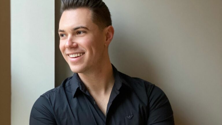 A smiling man looking away from the camera