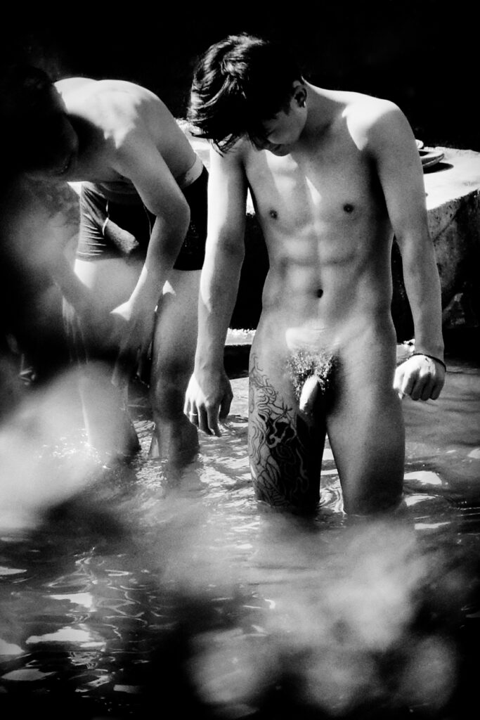 a photography by Liu Tao showing two men bathing, one naked with penis exposed