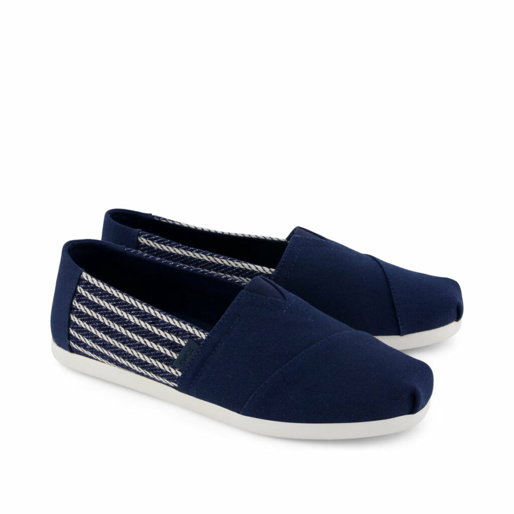 A product shot of the TOMS Alpargata slip-on shoes with nautical stripes in navy blue as part of Attitude's spring shoes shopping gallery