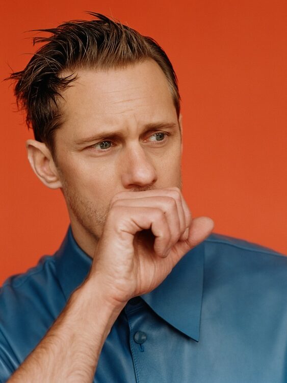 Alexander Skarsgård with his hand in a fist covering his mouth
