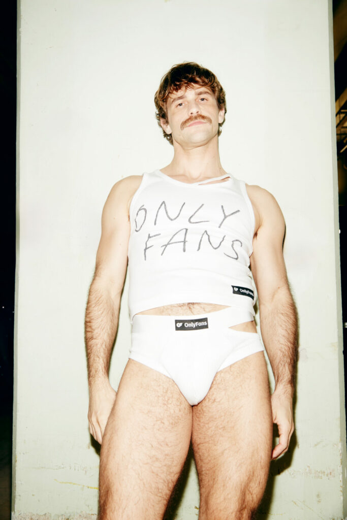 A model backstage at the LGN Louis Gabriel Nouchi Autumn/Winter 2026 runway show at Paris Fashion Week wearing the collaboration with OnlyFans