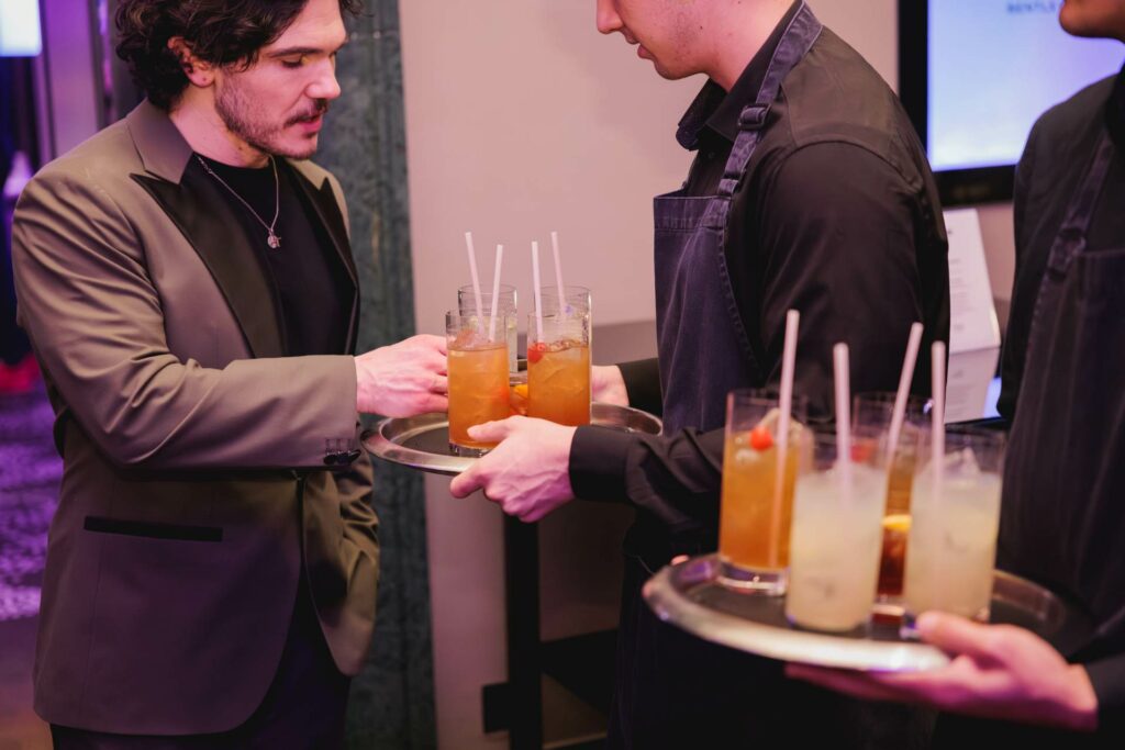 Fra Fee taking an M&S cocktail from a waiter at the Attitude 101 2026 event