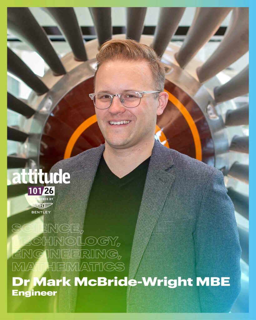Dr Mark McBride-Wright MBE standing in front of an aeroplane engine smiling, with the Attitude 101 logo in the lower left