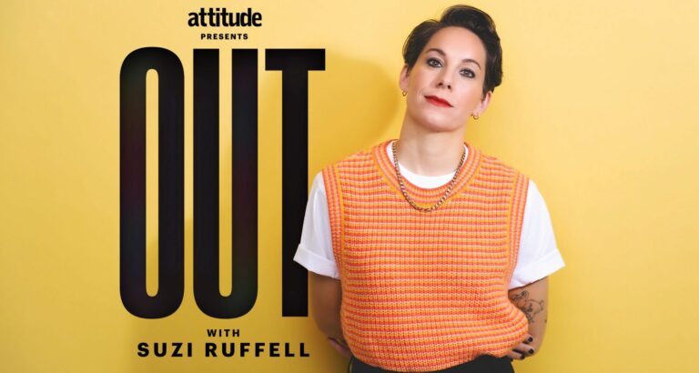 Suzi Ruffell wearing an orange jumper and black trousers standing against a yellow backdrop with the logo Attitude Presents out with Suzi Ruffell behind her