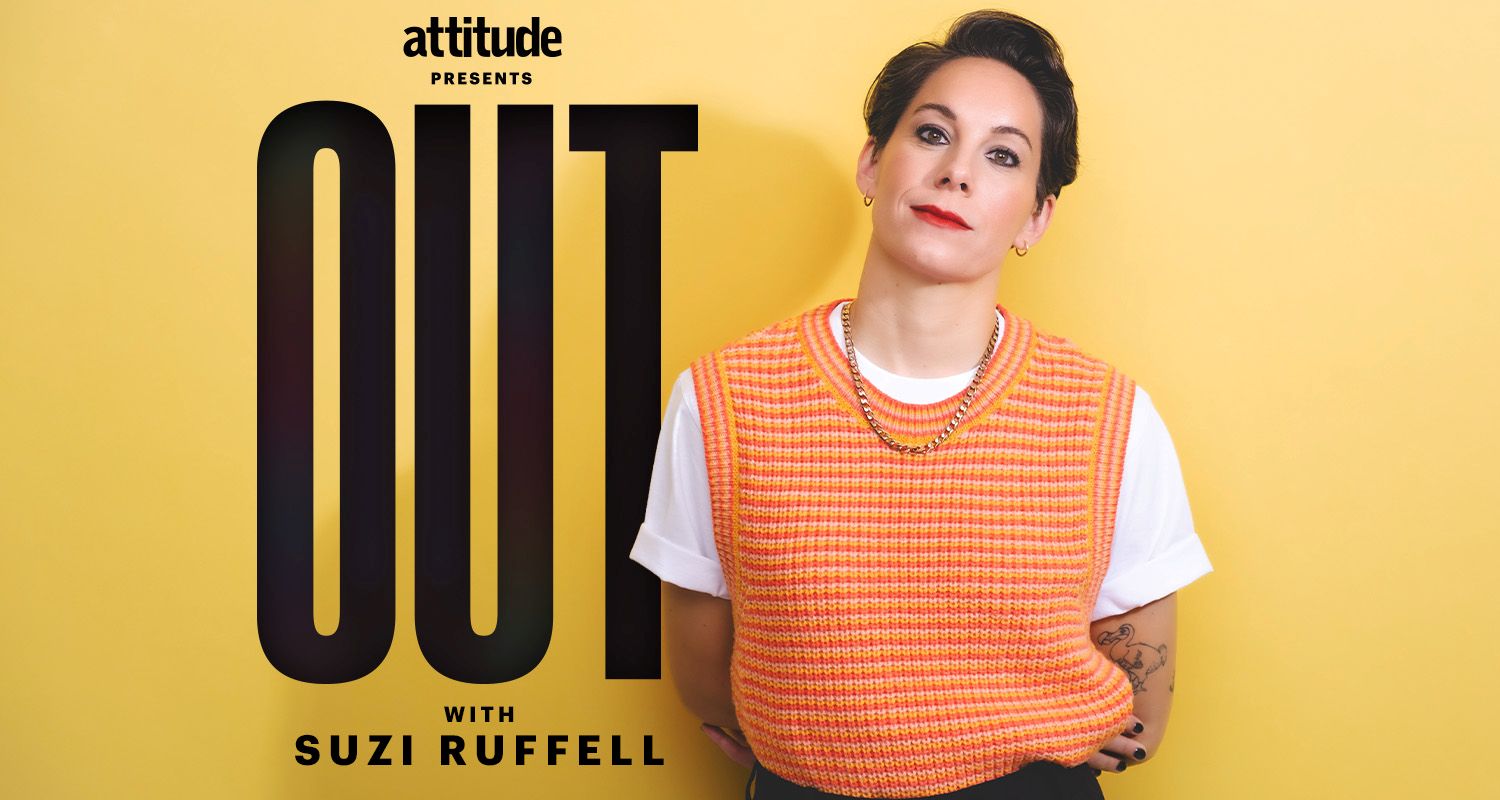 Suzi Ruffell wearing an orange jumper and black trousers standing against a yellow backdrop with the logo Attitude Presents out with Suzi Ruffell behind her