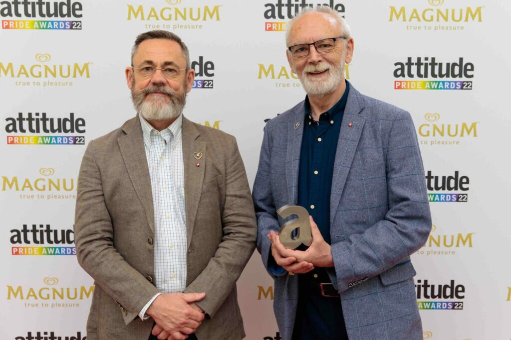 Rupert Whitaker and Martyn Butler OBE at the Attitude Pride Awards 2022 holding their award on the red carpet