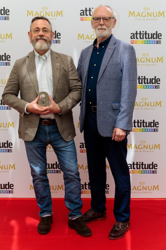 Rupert Whitaker and Martyn Butler OBE at the Attitude Pride Awards 2022 holding their award on the red carpet