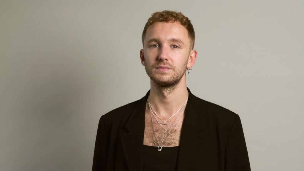 A photograph of the author, Curtis Garner, in a black jacket against a grey background