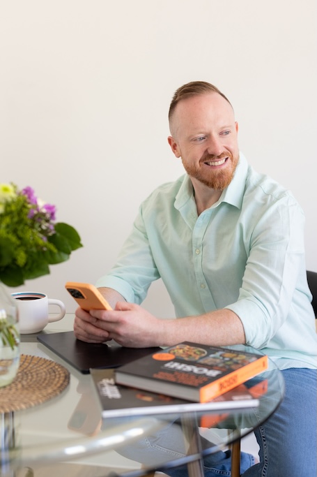 Daniel O&rsquo;Shaughnessy smiling on his phone