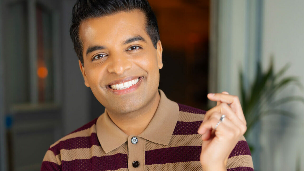 Suki Sandhu smiling in a striped T-shirt