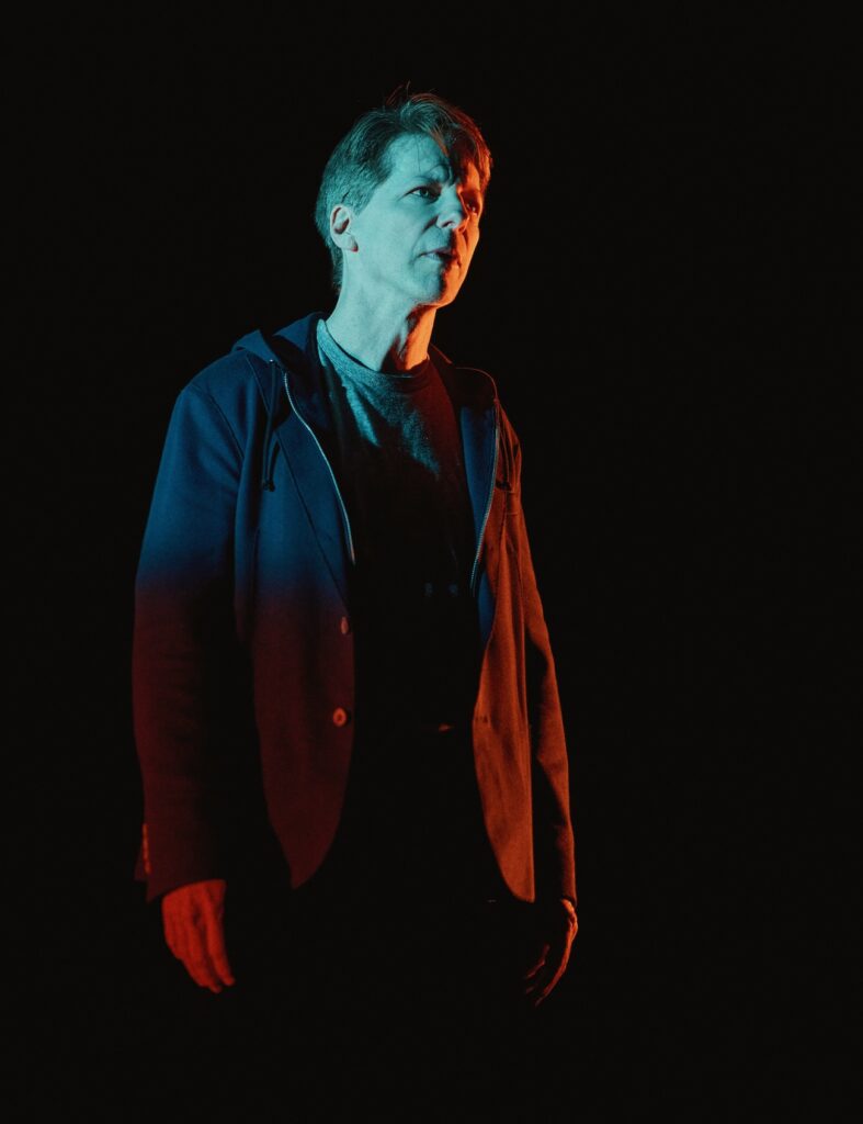 Sean Hayes in The Unknown dimly lit by an overhead light