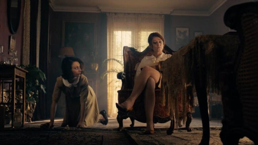 a still from the Duke of Burgundy showing one character sitting and the other crawling around on the floor