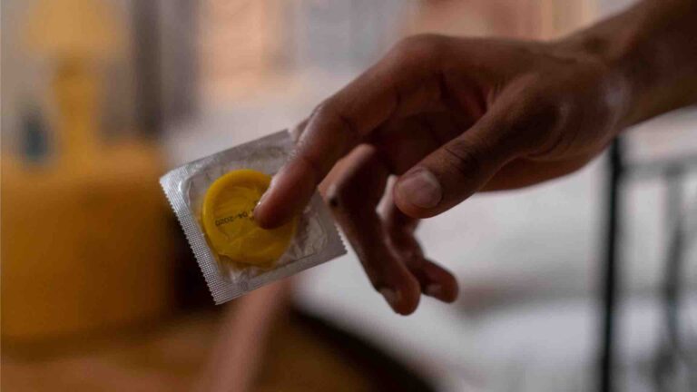 a man holding up a yellow condom