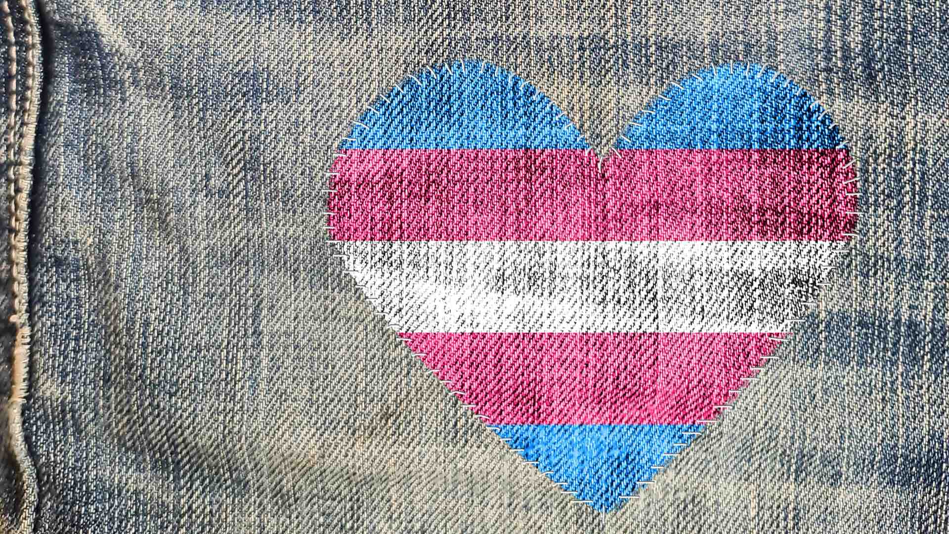 trans flag in the shape of a heart patch worked into a pair of jeans