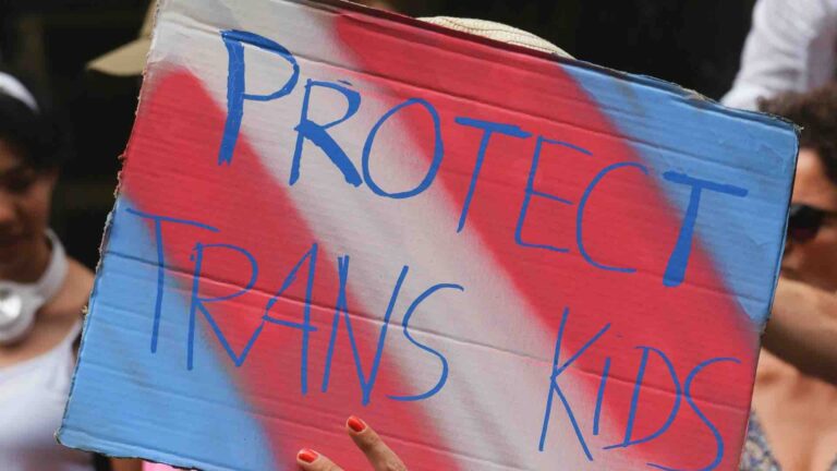 A sign stating "protect trans kids"