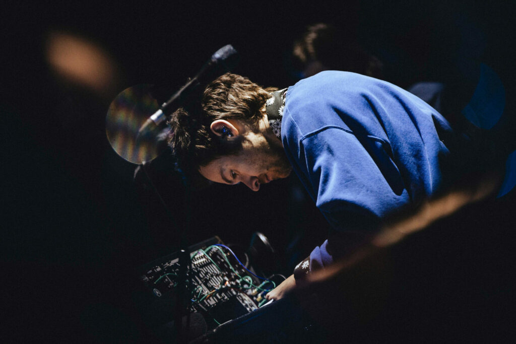 harry photographed from the side playing an electronic instrument