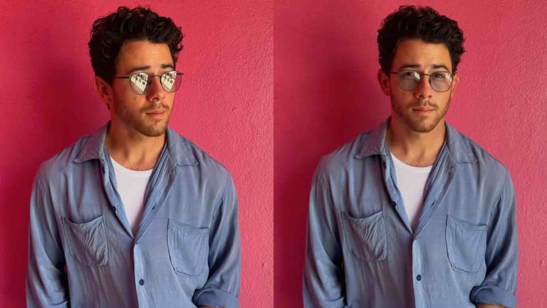 Nick Jonas in a denim jacket and glasses