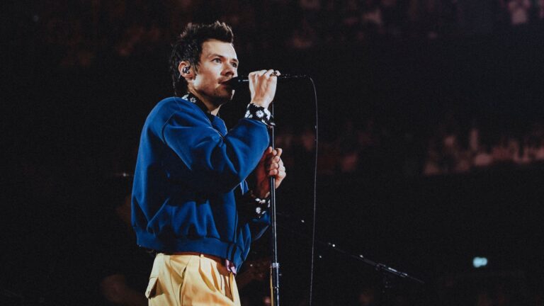 Harry Styles takes to the stage in Manchester in a blue jumper (Images: Anthony Pham)
