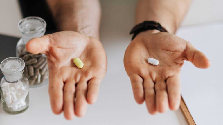 Doctor holding two pills in his hands