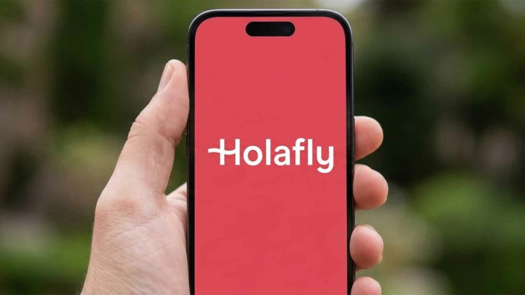 Hand holding a phone with the Holafly logo on it