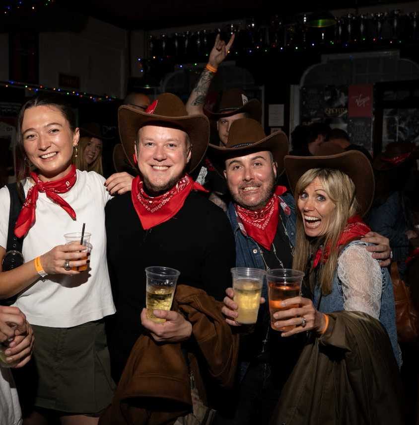 People in cowboy hats and red ned scarves at the Shania Twain gig at Shacklewell Arms