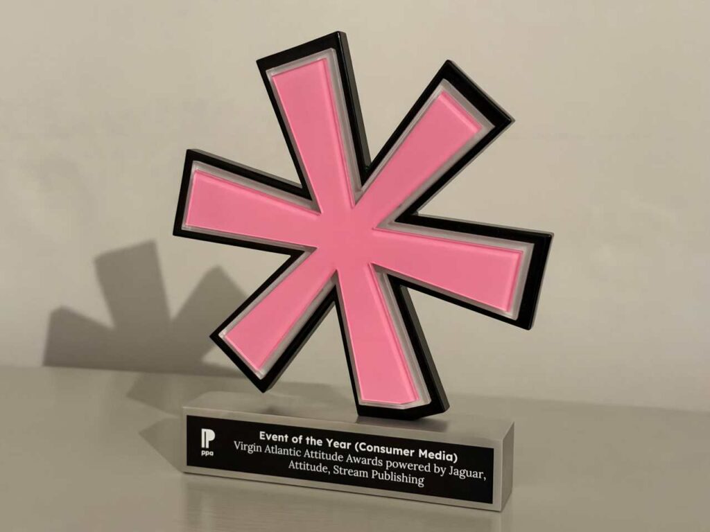 An award trophy featuring a large pink asterisk symbol with a black and white border, mounted on a rectangular silver base. The plaque on the base has the ppa logo and reads: "Event of the Year (Consumer Media), Virgin Atlantic Attitude Awards powered by Jaguar, Attitude, Stream Publishing."