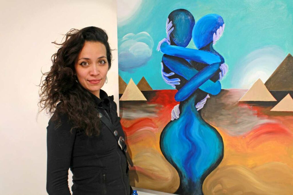 Daniella McNulty stands in front of her painting The Persistence of Temptation