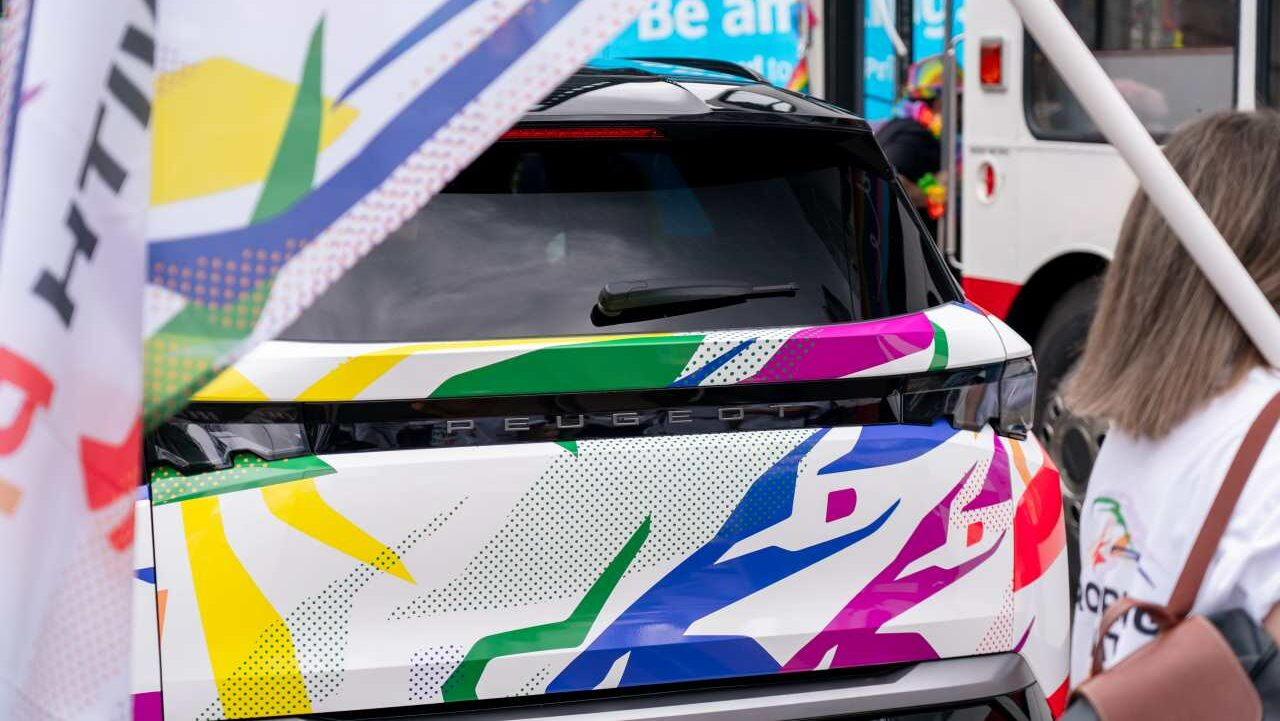 A Peugeot car covered in Pride livery