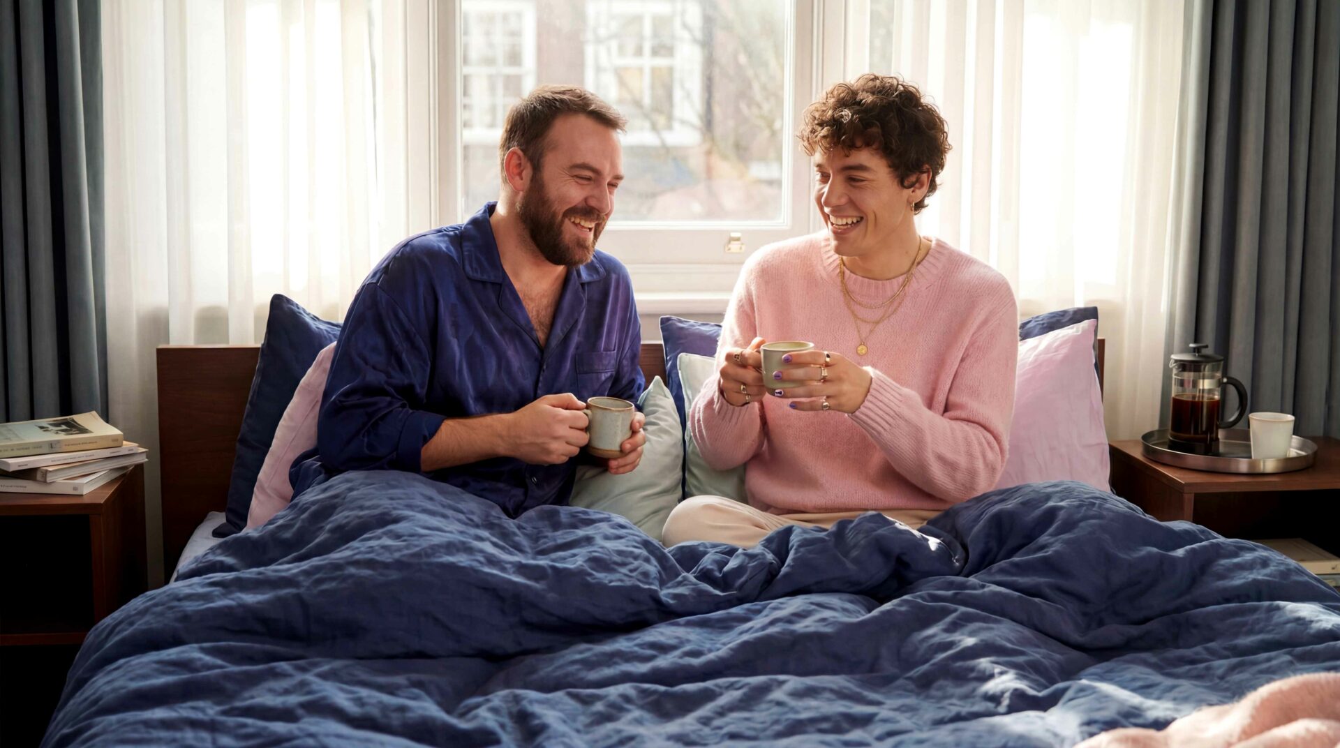Two men sitting on a bed