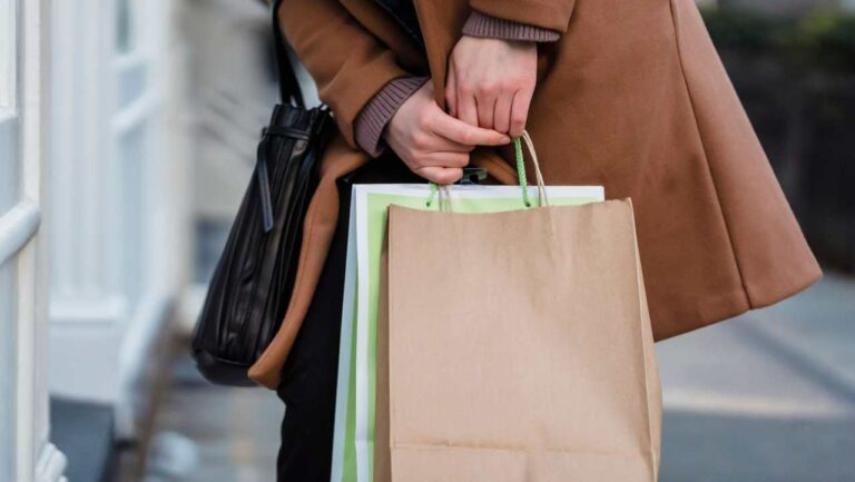 A close up of a person holding shopping bags