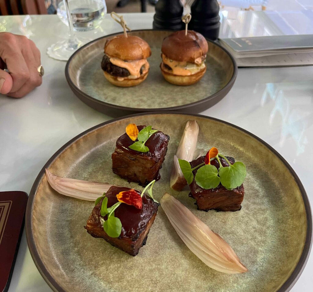 Wagyu beef sliders and beautifully braised beef rib in a smoky glaze, with pickled shallots at Ottie's restaurant in Bertrand's Townhouse