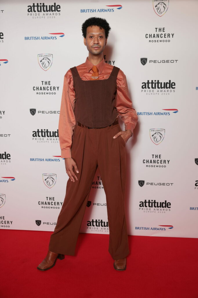 tia kofi in an oirange shirt and brown trousers and top