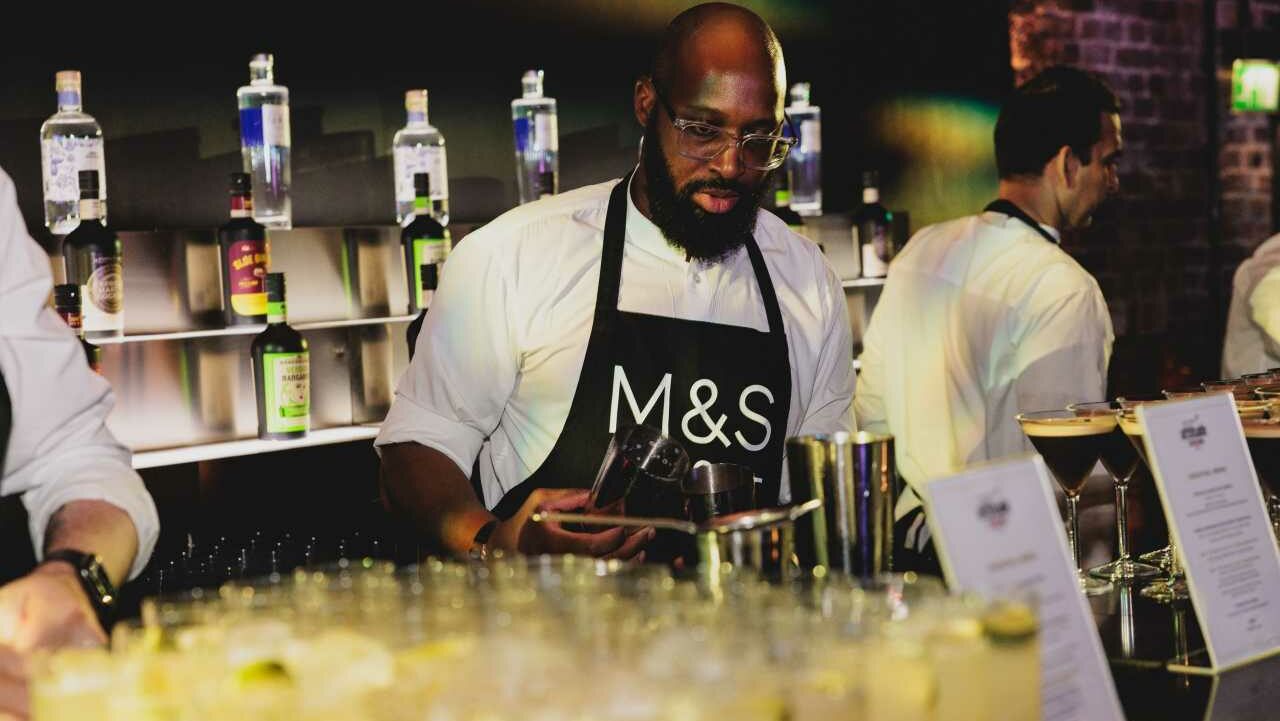 A waiter wearing an M&S apron serving drinks at the Attitude Awards